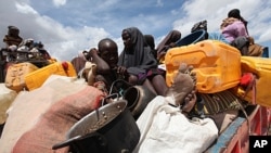 Internally displaced families wait to board trucks as they travel back to their home regions from Ala-yasir camp closed by the al Shabaab militias, in Lower Shabelle, 50 km (31 miles) south of Somalia's capital Mogadishu, October 15, 2011.