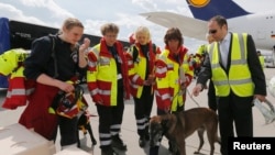 Members of Germany's NGO organization International Search and Rescue (ISAR- Germany) prepare sniffer dog Apache to board their flight to Nepal from Frankfurt airport, April 26, 2015. 
