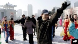 12일 북한이 로켓 발사에 성공했다고 발표한 가운데, 평양대극장 주변에서 기뻐하는 주민들.