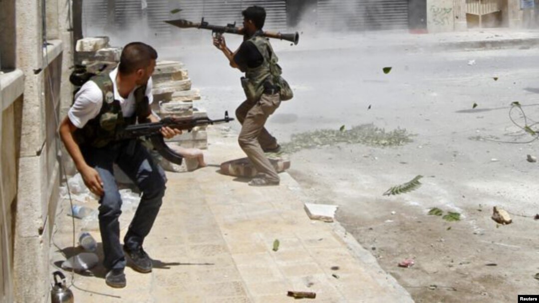 Un rebelde se dispone a disparar con un lanzagranadas a un tanque del ejército sirio en Aleppo