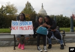 Trump Protests Washington: Washington area high school students sitting on a park bench, from left, Makeda Lydia, 14, Sarah Tewodros, 14 and Serwah Lydia, 17, protest on Capitol Hill in Washington, Nov. 15, 2016.