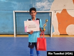 Salah satu anak disabilitas siswa SLB menunjukkan piala dan sertifikat pemain terbaik dalam SLB Futsal Festival di Bandung, Februari 2018 (foto: VOA/Rio Tuasikal)