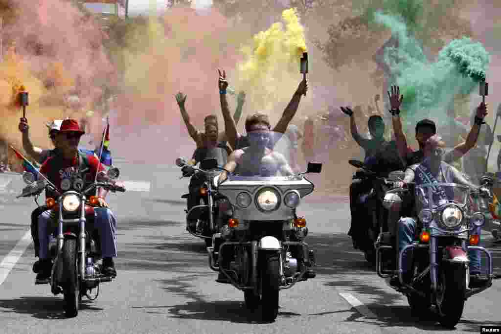 A group riding on motorcycles carry smoke torches during the 44th annual Los Angeles Pride parade in West Hollywood, California, USA, June 8, 2014.