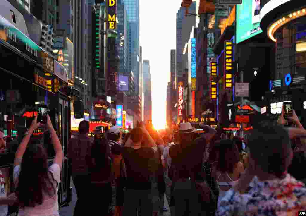 غروب آفتاب برفراز آسمان نیویورک نظر عابران پیاده در میدان تایمز را به خود جلب کرده است. &nbsp;