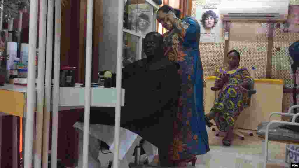Mata na hobbasa wajen yin sana'o'i a Nijar. Anan mace kewa na maza aski a Niamey, 14 ga Satumba, 2014.