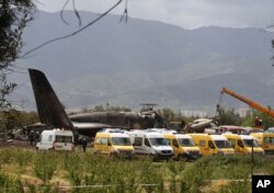 Firefighters and civil security officers work at the scene of a fatal military plane crash in Boufarik, near the Algerian capital, Algiers, Apr. 11, 2018.