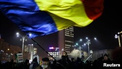 Một người biểu tình vẫy cờ Romania trong một cuộc biểu tình ở thủ đô Bucharest, Romania, ngày 3 tháng 2, 2017. 