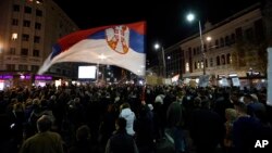 Seorang pria mengibarkan bendera Serbia dalam unjuk rasa di Beograd, Serbia, 9 Maret 2019.