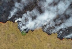 An aerial view shows smoke rising over a deforested plot of the Amazon jungle in Porto Velho, Rondonia State, Brazil, in this Aug. 24, 2019 picture taken with a drone.