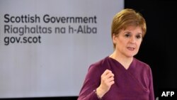 FILE - Scotland's First Minister Nicola Sturgeon gestures as she holds a briefing on the coronavirus outbreak in Edinburgh, March 26, 2020.
