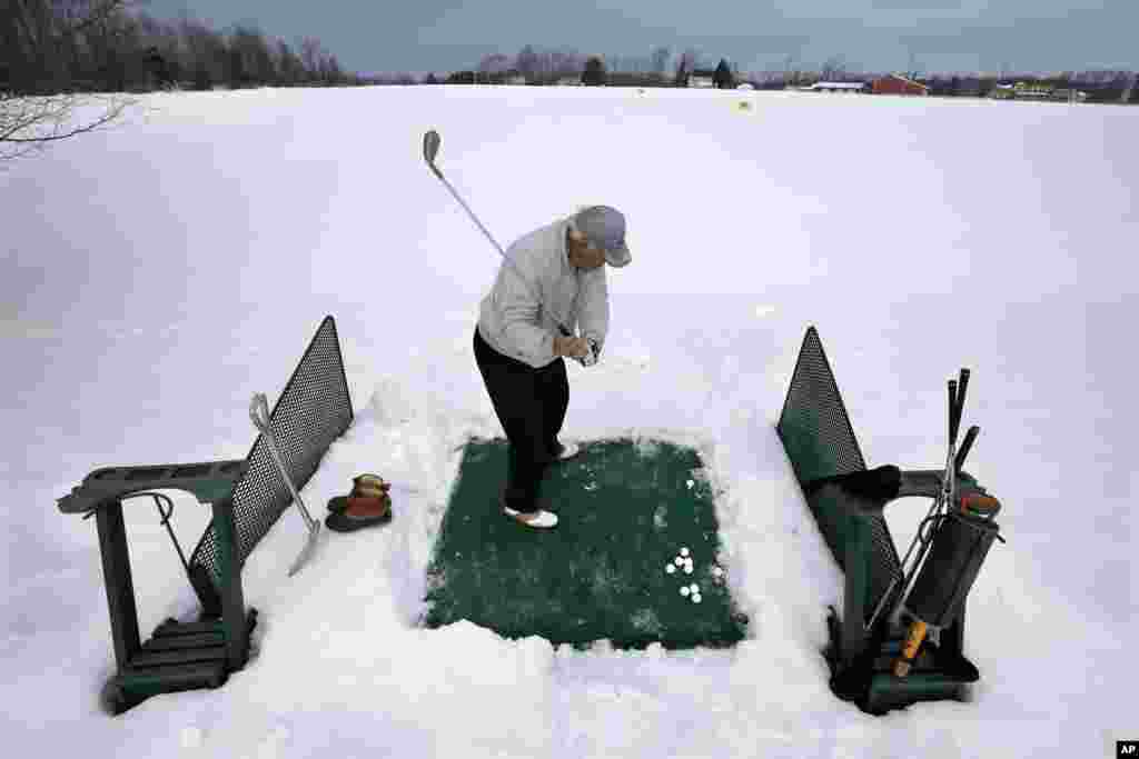 Rich Lukasik hits practice golf shots in the snow in Cream Ridge, New Jersey, USA.