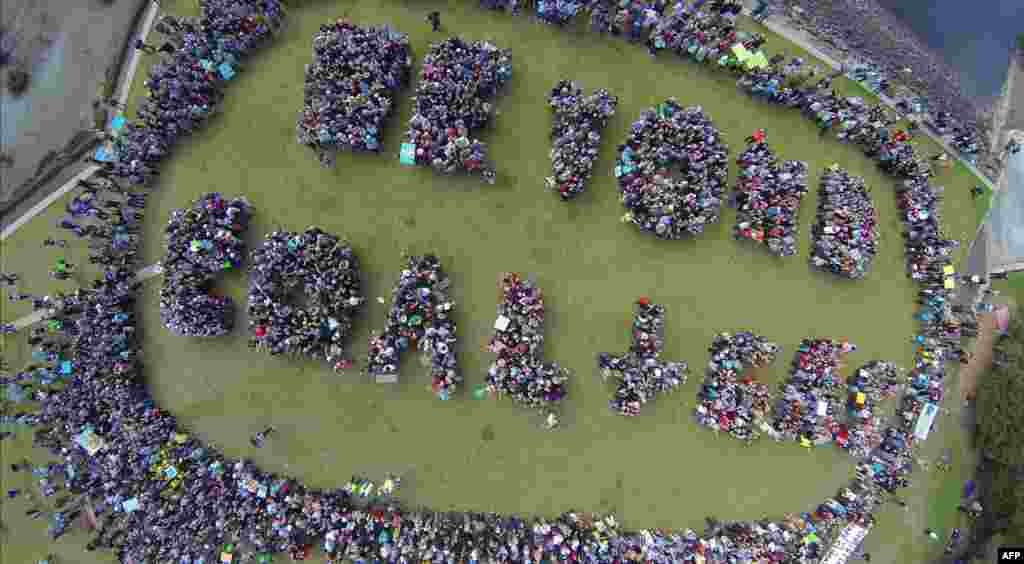 In this handout picture taken from a drone, environmental protesters form the words "Beyond Coal + Gas" during a meeting in a park in Sydney, Australia, as part of a global protest on climate change.
