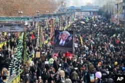 FILE - Iranians carry a banner showing a caricature of U.S. President Donald Trump during an annual rally commemorating the anniversary of the 1979 Islamic revolution, which toppled the late pro-U.S. Shah, Mohammad Reza Pahlavi, in Tehran, Iran, Feb. 10, 2017.