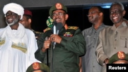 Sudan's President Omar al-Bashir (C) addresses supporters after the army announced it had seized back the town of Abu Kershola from the Sudanese Revolutionary Front, outside the military headquarters in Khartoum, May 27, 2013.