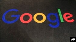 The logo of Google is seen on a carpet at the entrance hall of Google France in Paris, Monday, Nov. 18, 2019. (AP Photo/Michel Euler)