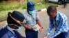 Police officers show a visitor how to disinfect his hands against the spread of coronavirus disease at State House in Harare, Zimbabwe, March 19, 2020.