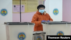 A woman votes at a presidential election in Chisinau, Moldova, Nov. 1, 2020. 