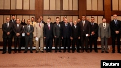 Libya's new Prime Minister Ahmed Maiteeq (6th L), President of the General National Congress Nouri Abusahmain (7th L) and other members of the new Libyan government pose for a group photo in Tripoli, May 26, 2014.