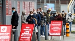 Antrean pelanggan untuk mengambil pesanan online di pasar elektronik Essen, Jerman, Selasa, 2 Februari 2021. (Foto AP / Martin Meissner)