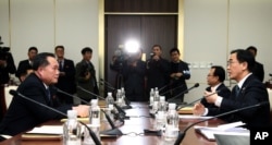 FILE - South Korean Unification Minister Cho Myoung-gyon, right, talks with the head of North Korean delegation Ri Son Gwon during their meeting at the Panmunjom in the Demilitarized Zone in Paju, South Korea, Jan. 9, 2018.