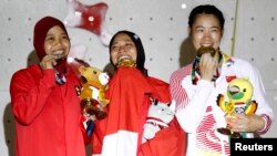 Atlet putri Indonesia peraih emas nomor speed panjat tebing, Aries Susanti Rahayu (tengah) didampingi peraih perak, Puji Lestari (kiri) dan peraih perunggu Culian He dari China. (Foto: Reuters)