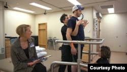 Paralyzed from the torso down, Jared Chinnock is seen standing after a procedure to allow him to move his legs again. (Mayo Clinic)