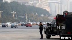 A Chinese policeman of the Special Weapons and Tactics (SWAT) team stands guard on a main street next to Tiananmen Square in Beijing, Oct. 31, 2013.