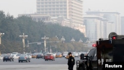 A Chinese policeman of the Special Weapons and Tactics (SWAT) team stands guard on a main street next to Tiananmen Square in Beijing, Oct. 31, 2013.