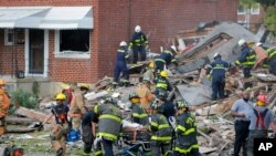 Para petugas Dinas Pemadam Kebakaran Kota Baltimore mengevakuasi korban dari reruntuhan bangunan setelah ledakan gas di Baltimore, Maryland, Senin, 10 Agustus 2020. 