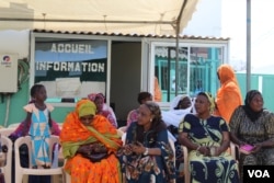 Women wait outside the Philippe Maguilen Senghor health center for free breast and cervical cancer screenings, in Yoff, Dakar, Senegal, April 22, 2017. (S. Christensen/VOA)