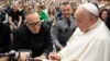 El papa Francisco autografía una botella de bourbon que sostiene el sacerdote católico de Kentucky reverendo Jim Sichko en el Vaticano el 1 de mayo de 2024. 