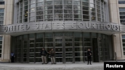 FILE - People stand outside a federal courthouse in New York City. 