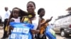 A woman carrying a baby holds a treated mosquito net during a malaria prevention action at Ajah in Eti Osa East district of Lagos, Nigeria, April 21, 2016.