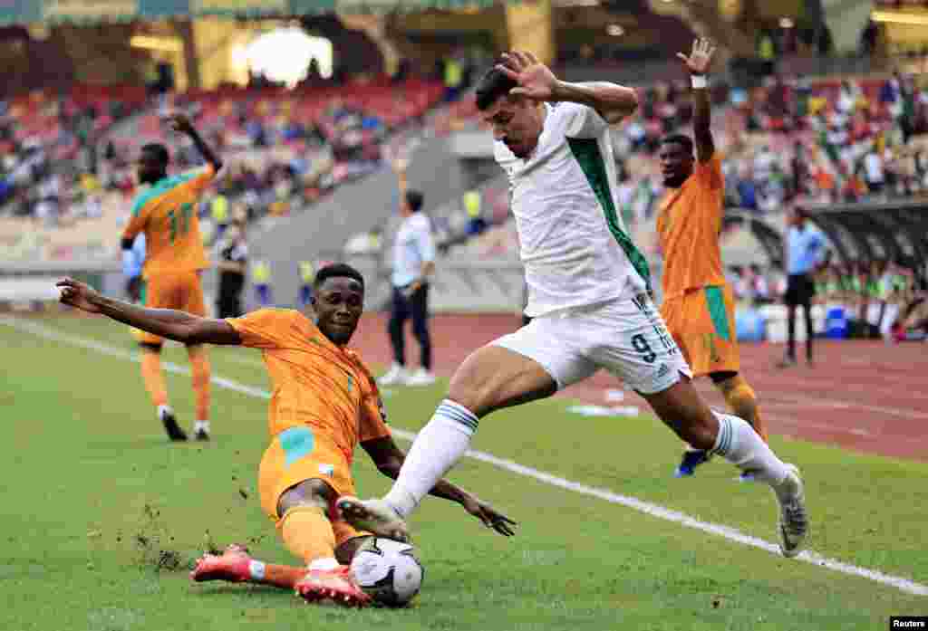 Ivory Coast&#39;s Odilon Kossounou in action with Algeria&#39;s Baghdad Bounedjah during the match between the two countries in Cameroon on Jan. 20, 2022.