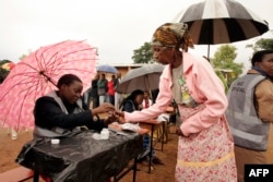 An old woman receives a mark on her finger with indelible ink prior to vote for Malawi's Tripartite elections at Malemia School Polling center, the home village of the incumbent president, May 20, 2014.