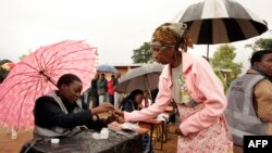 An old woman receives a mark on her finger with indelible ink prior to vote for Malawi's Tripartite elections at Malemia School Polling center, the home village of the incumbent president, May 20, 2014.