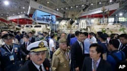 Visitors look at the military vehicles during the 12th China International Aviation and Aerospace Exhibition, also known as Airshow China 2018, Tuesday Nov. 6, 2018, in Zhuhai city, south China's Guangdong province.