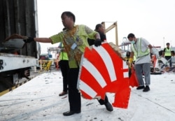 Para pekerja mengumpukan serpihan dan barang-barang yang diyakini berasal dari penerbangan Lion Air JT610 ke sebuah truk di Pelabuhan Tanjung Priok, Jakarta, 2 November 2018. (Foto: REUTERS/Edgar Su)