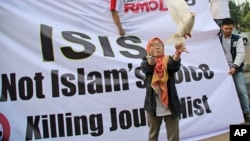 FILE - A Muslim woman releases a dove as a symbol of peace during a rally against the Islamic State group, in Jakarta, Indonesia.