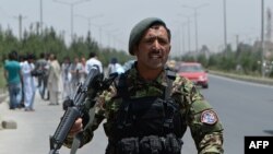 کابل میں افغان فوج کا ایک سپاہی ایک راکٹ حملے کے بعد راہگیروں کو دھماکے کی جگہ سے ہٹانے کی ہدایات دے رہا ہے۔ فائل فوٹو اے ایف پی