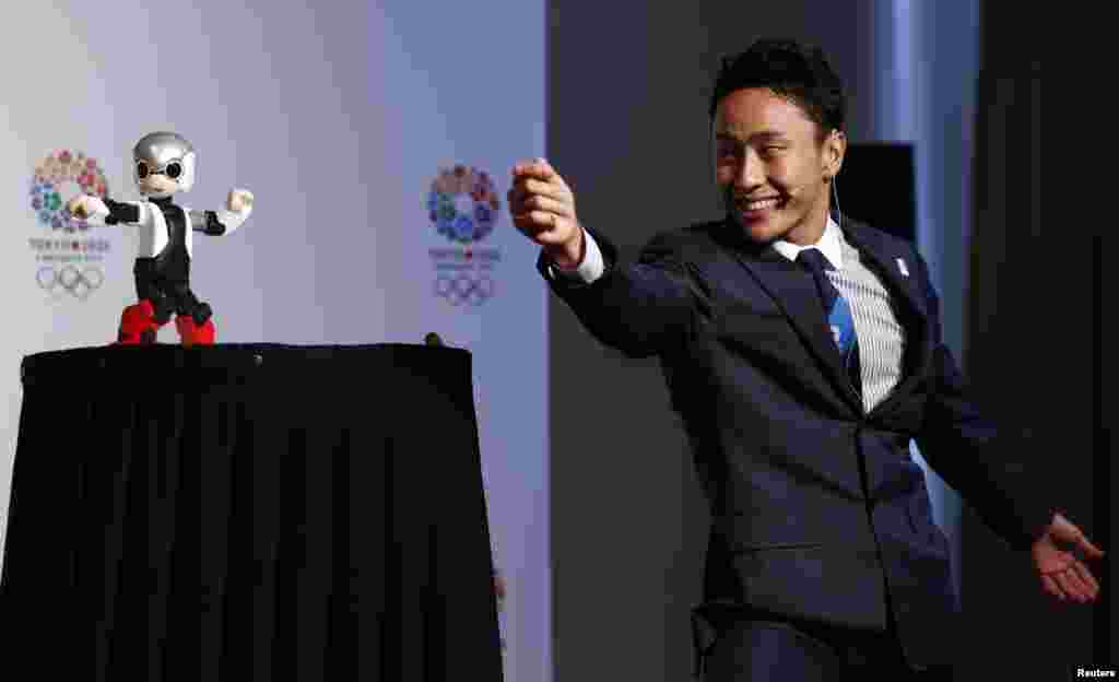 Japanese fencing Olympian Yuki Ota participates in a demonstration with talking robot Mirata during a news conference in support of the Tokyo 2020 summer Olympics candidacy in Buenos Aires, Argentina. The International Olympic Committee (IOC) will elect the host city for the 2020 summer Olympics at their session Sept. 7.