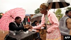 An old woman receives a mark on her finger with indelible ink prior to vote for Malawi's Tripartite elections at Malemia School Polling center, the home village of the incumbent president, May 20, 2014.