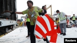 Para pekerja mengumpulkan puing-puing pesawat Lion Air dengan nomor penerbangan JT610 di Pelabuhan Tanjung Priok, Jakarta, 2 November 2018. (Foto: Reuters)
