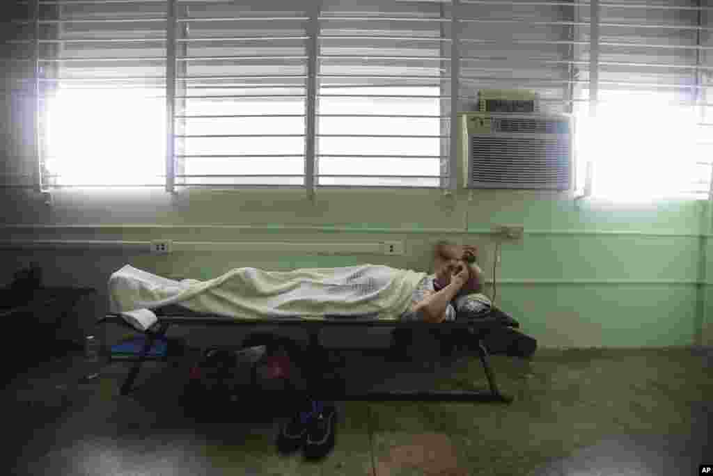 Un hombre descansa en una cama de un refugio en la escuela Berta Zalduondo en Fajardo, Puerto Rico, mientras afuera el huracán Irma ha comenzado a azotar la isla. AP Sep. 6, 2017.