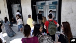 ປະຊາຊົນ ລຽນແຖວ ເພື່ອກົດເອົາເງິນ ອອກຈາກຕູ້ ATM ຢູ່ທະນາຄານແຫ່ງໜຶ່ງໃນເມືອງ Thessaloniki ທາງພາກເໜືອ ຂອງປະເທດ ກຣິສ, 27 ມິຖຸນາ 2015.