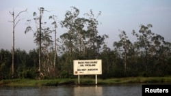 A warning sign belonging to the company Royal Dutch Shell is seen along the Nembe creek in Nigeria's oil state of Bayelsa Dec. 2, 2012.