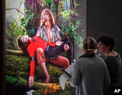 Visitors talk about the picture 'American Jesus: Hold me, carry me boldly' from US artist David LaChapelle at a preview of the exhibition 'Michael Jackson: On The Wall' at the Bundeskunsthalle museum in Bonn, Germany, March 21, 2019.