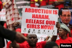 A man holds a placard calling for the release of secondary school girls abducted in the remote village of Chibok, during a protest along a road in Lagos, May 14, 2014.