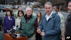 Interior Secretary Ryan Zinke, right, answers a reporters question after touring fire ravaged Paradise, Calif. with Agriculture Secretary Sonny Perdue, center, Nov. 26, 2018.