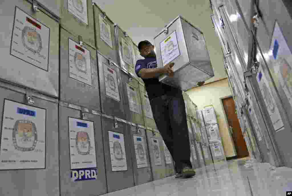 An Election Commission official walks among ballot boxes to be distributed to polling stations at a local government office in Jakarta, April 8, 2014. 